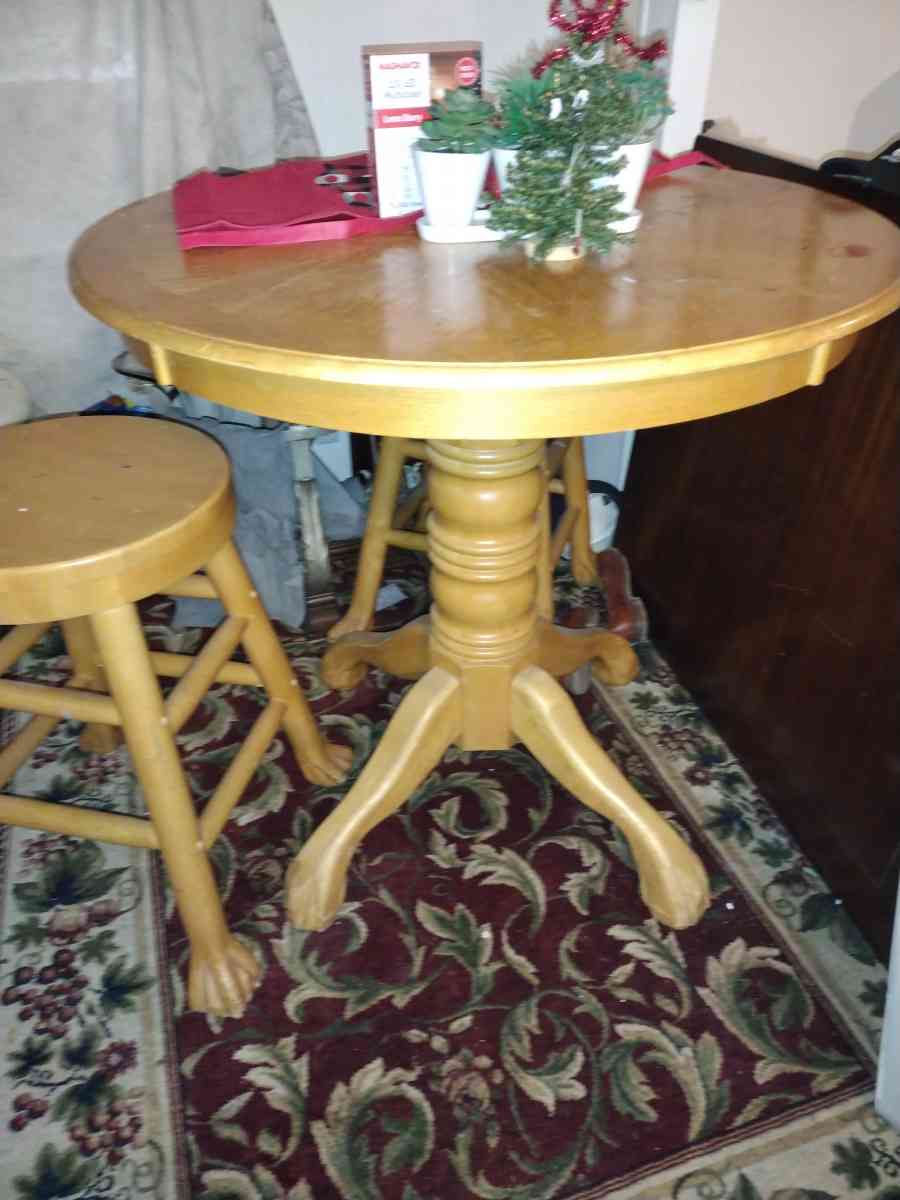 a light wooden high top table with two wooden stools