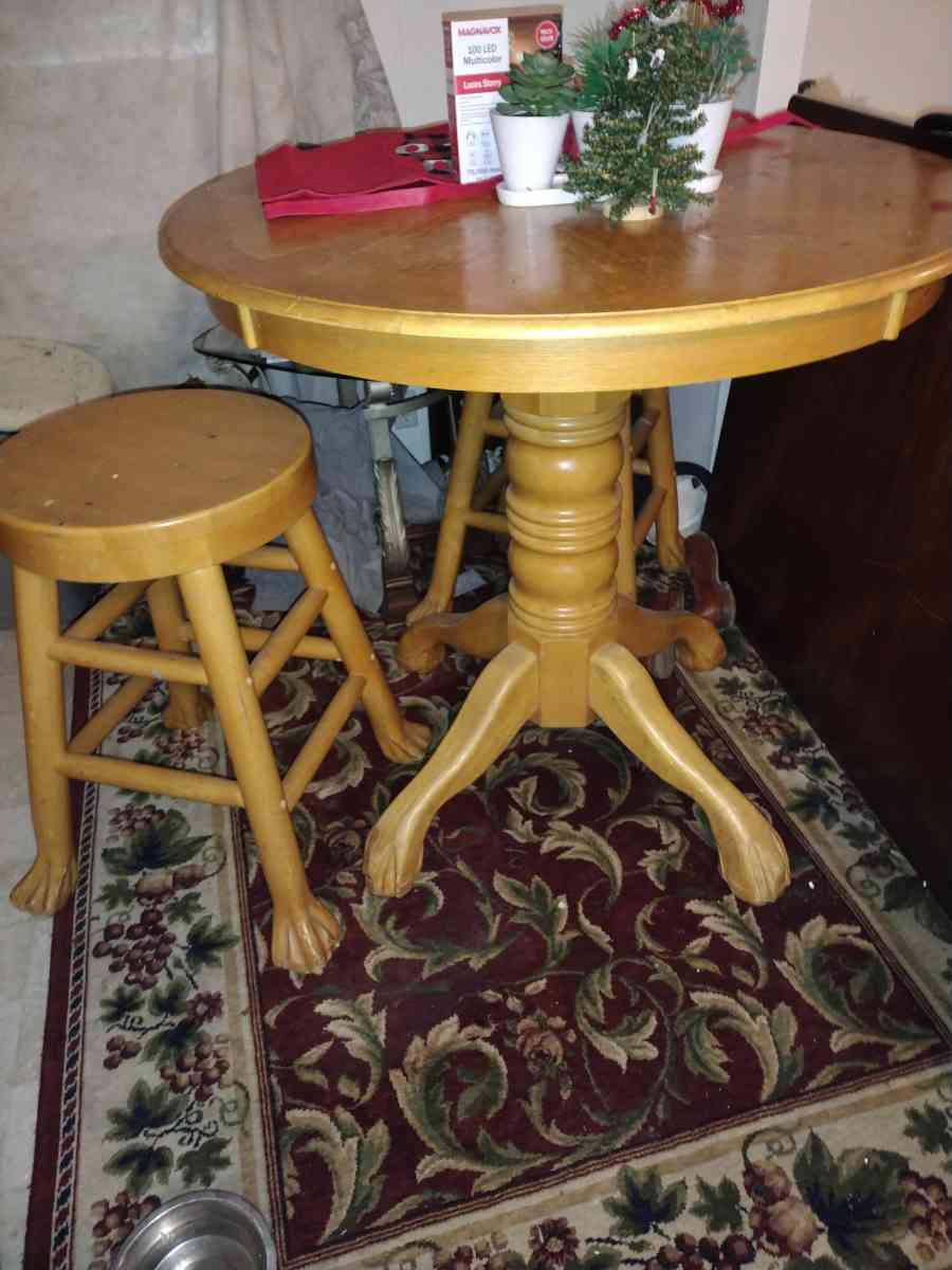 a light wooden high top table with two wooden stools