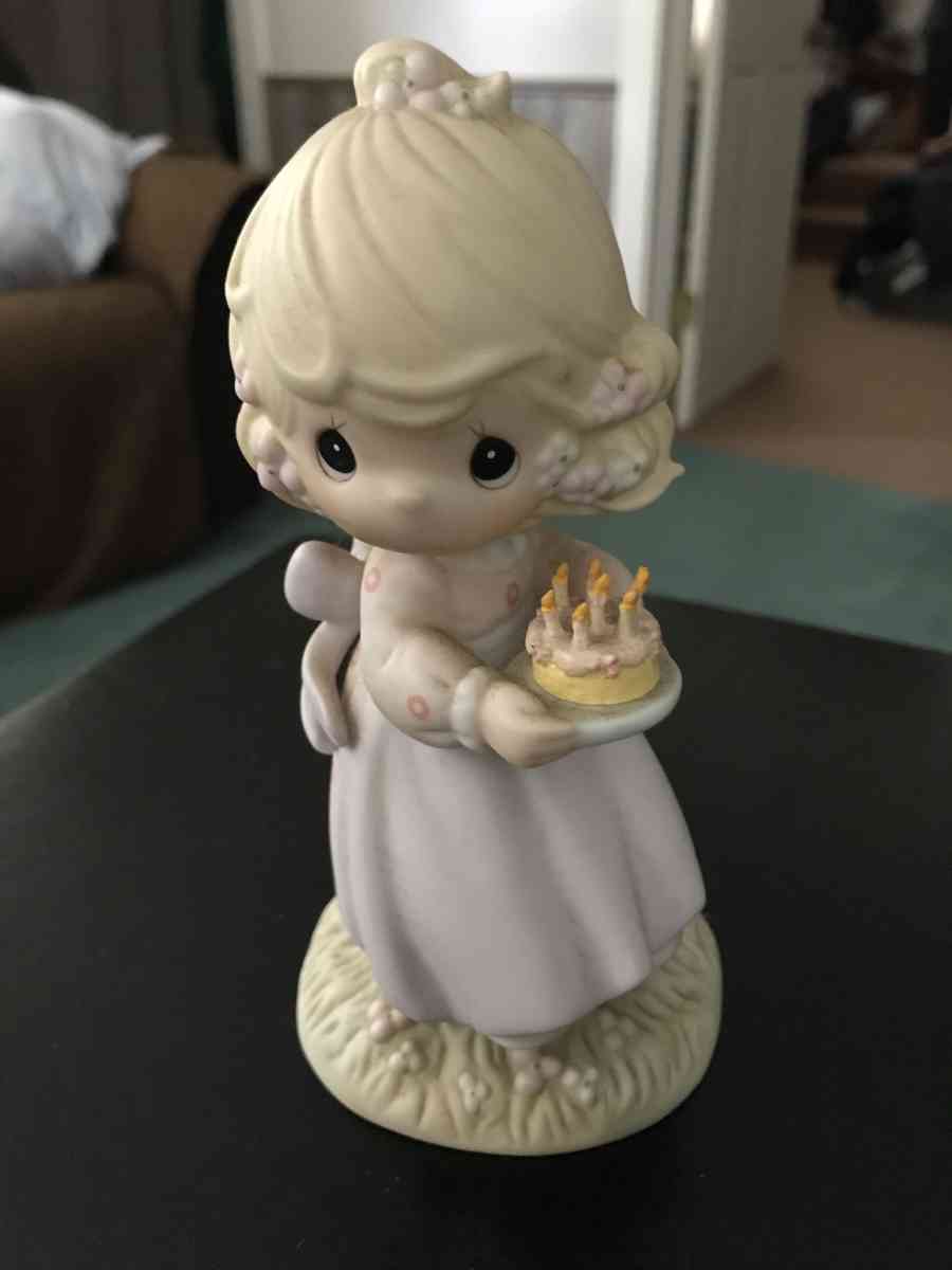 precious moment girl holding a cake