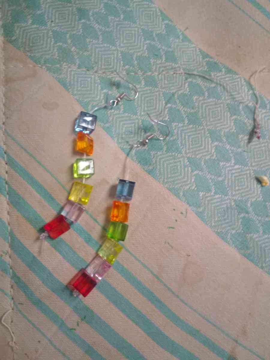 a religious wall hanging and two pairs of hand made earrings