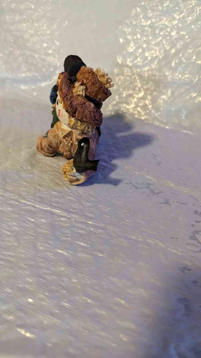 Resin Scarecrow Laying Down With Legs Bent Holding A Crow