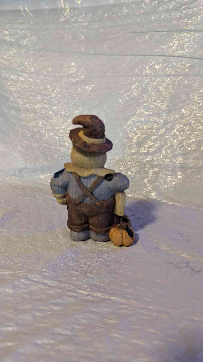 Happy Wood Scarecrow has a couple of Pumpkins and a little S