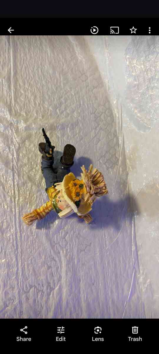 Resin Playful Scarecrow Laying On His Stomach With A Black C