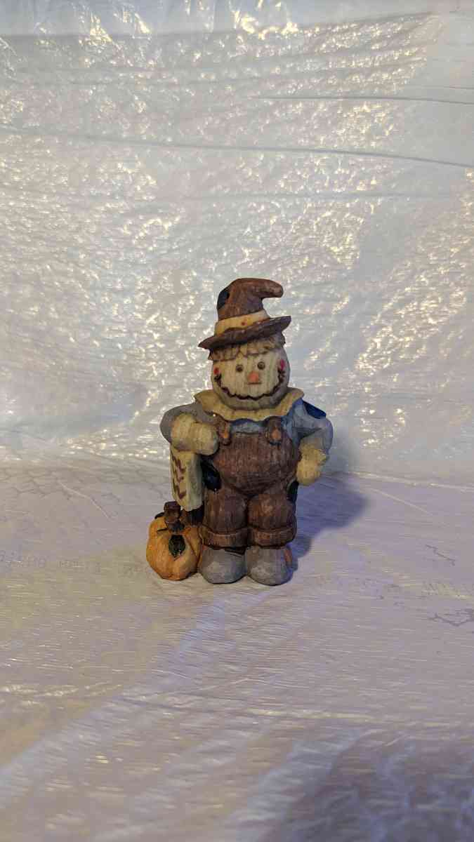 Happy Wood Scarecrow has a couple of Pumpkins and a little S