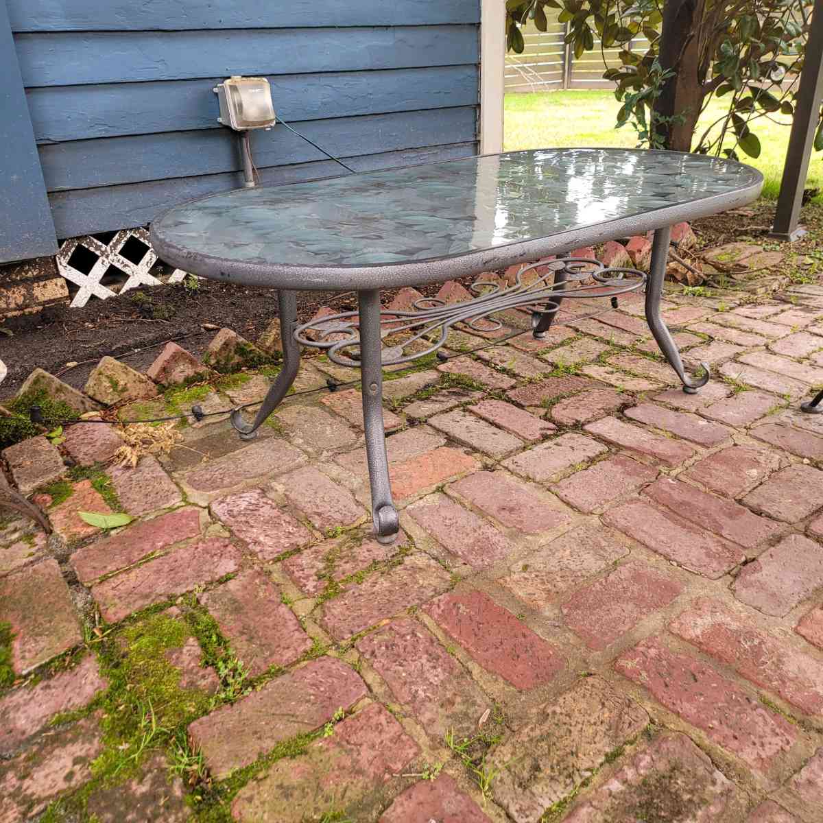 Oval outdoor glass coffee table with metal trim