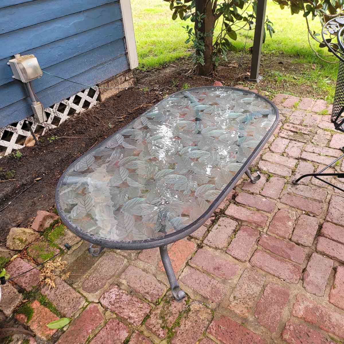 Oval outdoor glass coffee table with metal trim