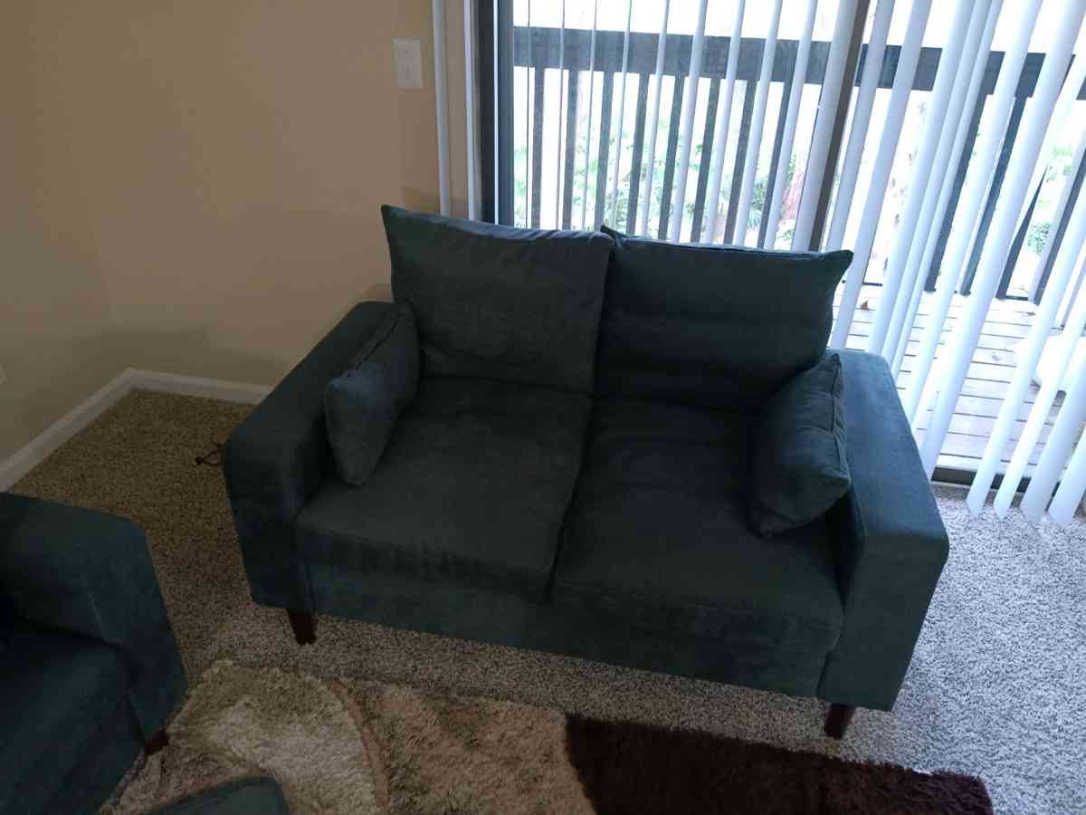 couch and loveseat and cabinet with glass shelves very clean