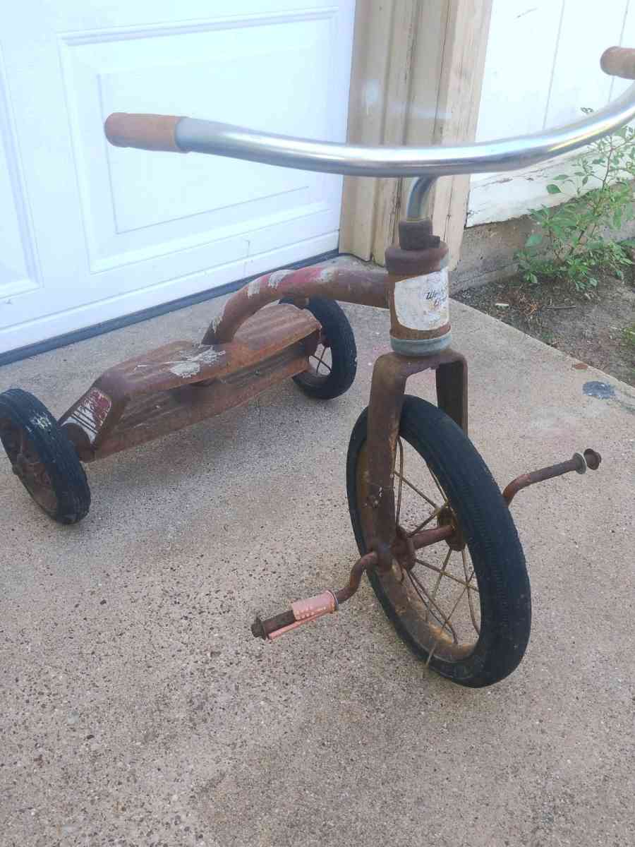 antique tricycle and a antique grape soda cooler