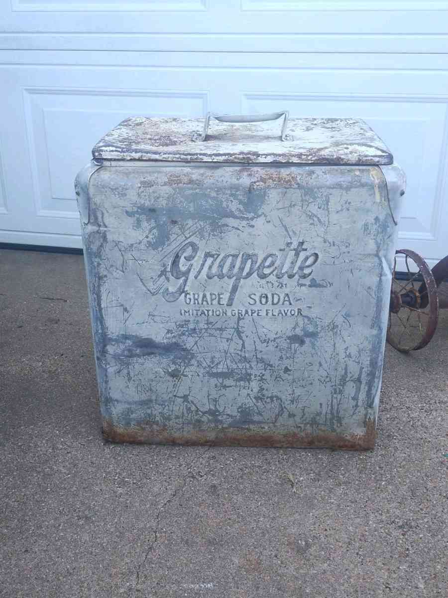 antique tricycle and a antique grape soda cooler