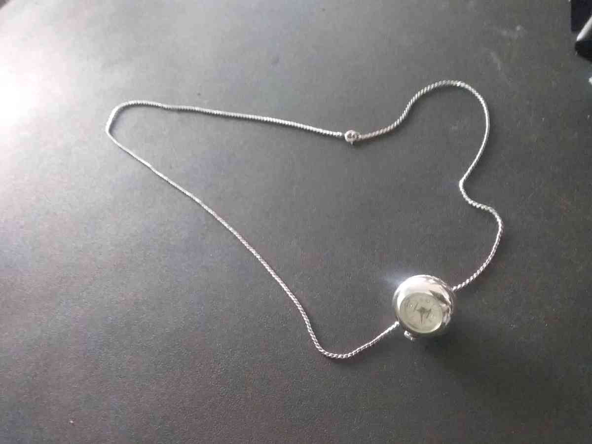 silver necklace with timepiece