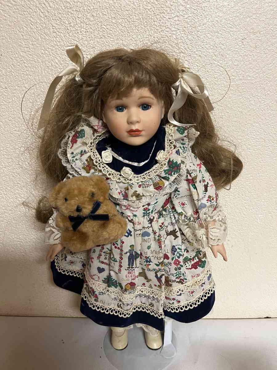 vintage porcelain doll hoding stuffed bear