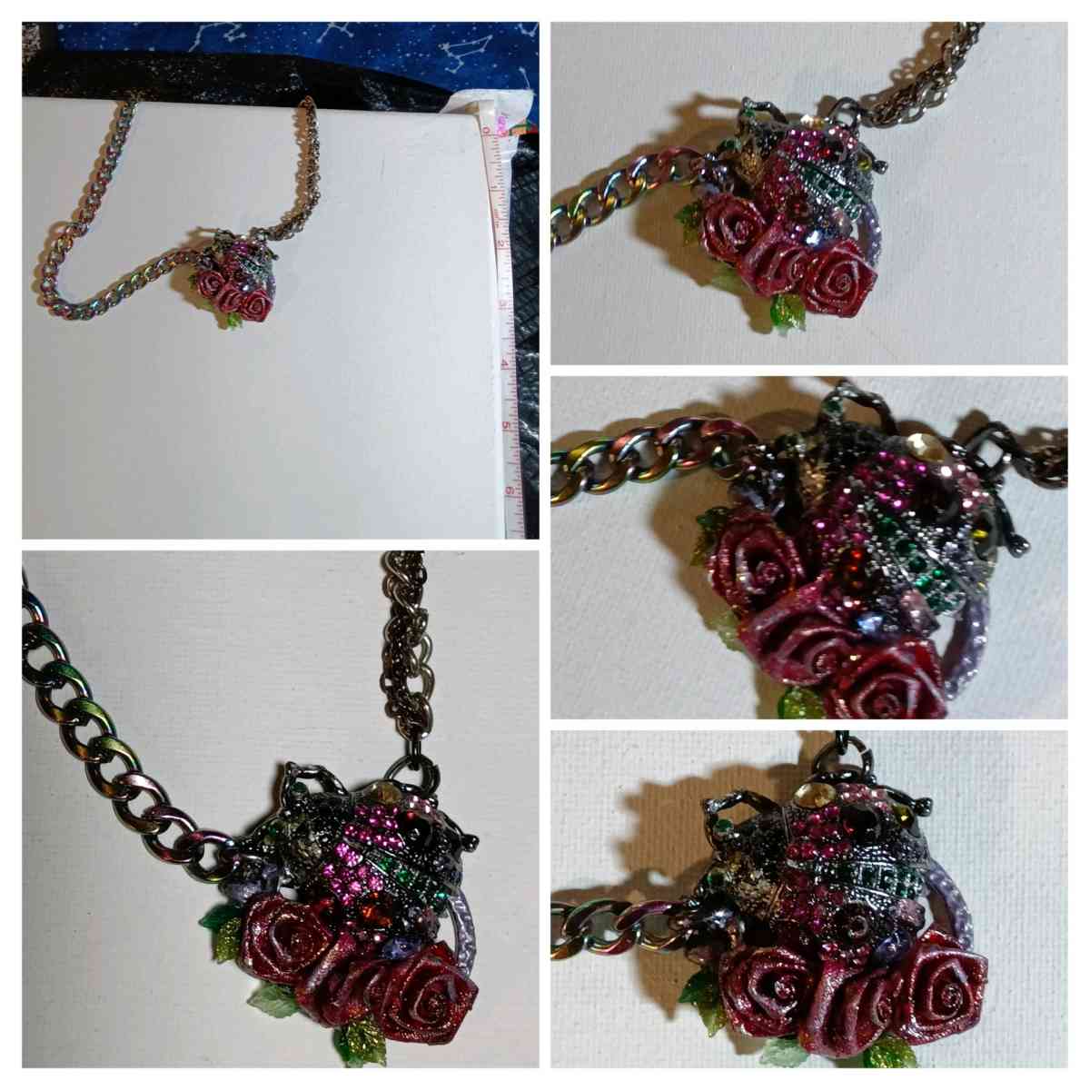 a bejeweled ladybug and roses on a black metal chain